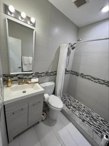 a bathroom with a toilet and a sink and a mirror at The Pearl Beachside Apartments on Hollywood Beach in Hollywood
