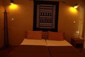 1 dormitorio con 1 cama y una foto en la pared en Bopath Falls Rock Chalets, en Agalawatta