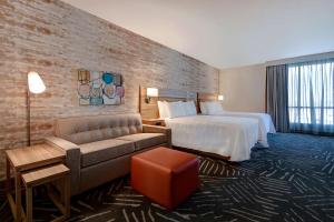 a hotel room with a bed and a couch at Home2 Suites By Hilton Anaheim Resort in Anaheim