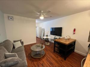 a living room with a couch and a flat screen tv at The Pearl Beachside Apartments on Hollywood Beach in Hollywood