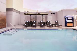 a swimming pool with chairs and a table at Hampton Inn & Suites Irvine/Orange County Airport in Irvine