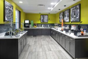 a large kitchen with dark cabinets and yellow walls at Hampton Inn & Suites Irvine/Orange County Airport in Irvine