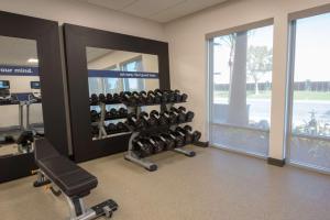 a gym with rows of dumbbells and a mirror at Hampton Inn & Suites Irvine/Orange County Airport in Irvine