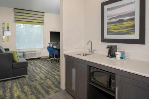 a hotel room with a sink and a living room at Hampton Inn & Suites Irvine/Orange County Airport in Irvine