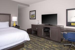 a hotel room with a bed and a flat screen tv at Hampton Inn & Suites Irvine/Orange County Airport in Irvine