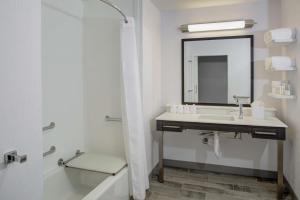 a white bathroom with a sink and a mirror at Hampton Inn & Suites Irvine/Orange County Airport in Irvine
