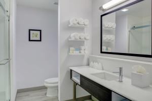 a white bathroom with a sink and a mirror at Hampton Inn & Suites Irvine/Orange County Airport in Irvine