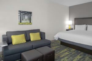 a hotel room with a bed and a couch at Hampton Inn & Suites Irvine/Orange County Airport in Irvine