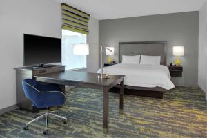 a hotel room with a bed and a desk with a computer at Hampton Inn & Suites Irvine/Orange County Airport in Irvine