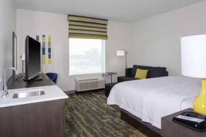 a hotel room with a bed and a sink at Hampton Inn & Suites Irvine/Orange County Airport in Irvine
