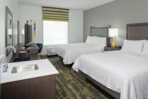 a hotel room with two beds and a sink at Hampton Inn & Suites Irvine/Orange County Airport in Irvine