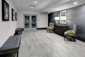 a waiting room with a couch and two chairs and a desk at Hampton Inn & Suites Irvine/Orange County Airport in Irvine