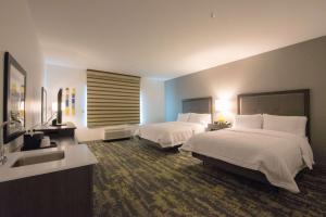 a hotel room with two beds and a sink at Hampton Inn & Suites Irvine/Orange County Airport in Irvine