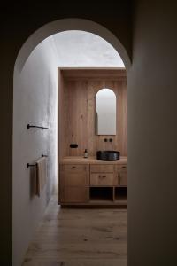 ein Bad mit einem Waschbecken und einem Spiegel in der Unterkunft fink Restaurant & Suites in Brixen
