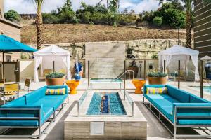 basen z niebieskimi ławkami i basen w obiekcie Hampton Inn & Suites by Hilton Mission Viejo Laguna San Juan Capistrano w mieście Mission Viejo