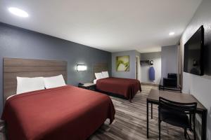 Postel nebo postele na pokoji v ubytování Americas Best Value Inn Buda