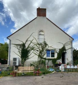 una casa bianca con una panchina davanti di Villa Christine Chambre Rose a Marchenoir