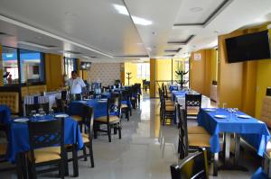 un comedor con mesas y sillas azules en Hotel Castillo Del Rey en Palenque