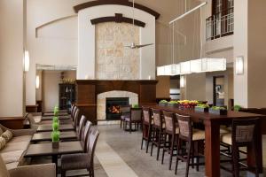 a dining room with a fireplace and a table and chairs at Hampton Inn & Suites San Marcos in San Marcos