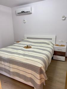 una cama con una manta a rayas encima en Holiday Home Korda, en Čapljina