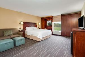 a bedroom with a bed and a couch and a tv at Hampton Inn Somerset in Somerset