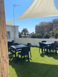 a group of tables and chairs under a white umbrella at Grenada Home in Praia a Mare