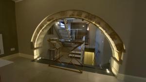 シラクーサにあるLanterne Magiche Ortigia Suitesの椅子と階段のある部屋のアーチ道