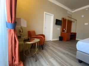 a room with a bed and a table and a chair at Lanterne Magiche Ortigia Suites in Siracusa