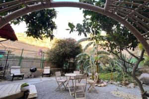 a patio with a table and chairs in a yard at Lodge Nature in quiet Montain - Private Jaccuzi and garden, Wifi - La Lézardière in San Bartolomé