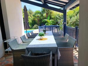 - une table avec des chaises et un parasol sur la terrasse dans l'établissement Près golfs et plages piscine chauffée, à Bidart