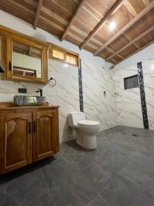 a bathroom with a toilet and a sink at Hermosa casa finca en Medellín con jacuzzi ! in Medellín