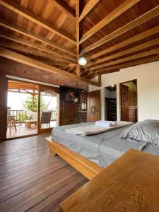 a bedroom with a large bed and a wooden ceiling at Hermosa casa finca en Medellín con jacuzzi ! in Medellín