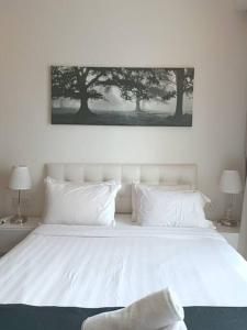 a bedroom with a white bed with two lamps at RM218 Bukit Bintang Balcony Studio Infinity Pool in Kuala Lumpur