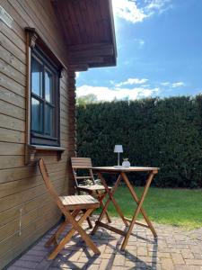 a picnic table and two chairs on a patio at TinyHouse Meereszauber- ruhige Lage, eigener Garten, Grill in Wolgast