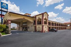 a building with a car parked in a parking lot at Americas Best Value Inn Buda in Buda