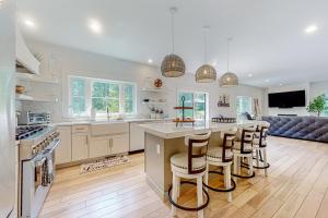 a kitchen with white cabinets and a bar with stools at Salisbury Sanctuary in Salisbury