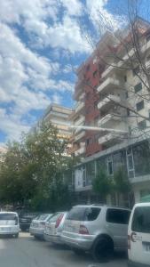 una fila de autos estacionados frente a un edificio en Vlora Stadium 2 BR Central Apartment, en Vlorë