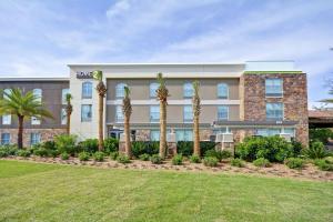 a hotel with palm trees in front of a building at Home2 Suites By Hilton St. Simons Island in Saint Simons Island