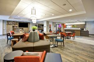 a lobby with a couch and tables and chairs at Home2 Suites By Hilton St. Simons Island in Saint Simons Island