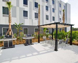 um pátio com mesas e cadeiras em frente a um edifício em Hampton Inn & Suites Sarasota / Bradenton - Airport em Sarasota
