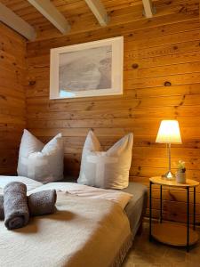 a bedroom with wooden walls with a bed and a lamp at TinyHouse Meereszauber- ruhige Lage, eigener Garten, Grill in Wolgast +15 photos