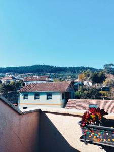 un jarrón de flores sentado en la cornisa de un edificio en Los Abriles, en Baiona