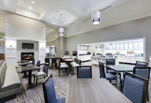 a restaurant with tables and chairs and a fireplace at Homewood Suites by Hilton Saint Louis-Chesterfield in Chesterfield
