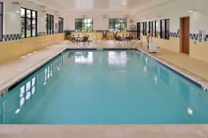 a large swimming pool with blue water in a building at Hampton Inn & Suites St. Louis - Edwardsville in Glen Carbon