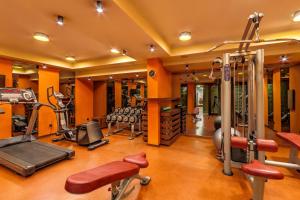 een fitnessruimte met oranje muren en veel fitnessapparatuur bij private apartment hotel Regnum Bansko in Bansko