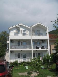 a large white building with chairs in front of it at Kuća Moric in Tivat