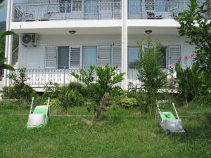 a house with two green scooters parked in the grass at Kuća Moric in Tivat