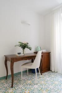 escritorio con silla blanca y mesa de madera en Residenza Amalphia, en Amalfi