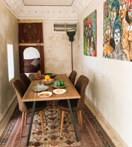 een eetkamer met een houten tafel en stoelen bij Riad la Cigale in Marrakesh