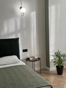 Un dormitorio con una cama y una mesa con una planta en Aparthotel Old Avenue, en Tiflis